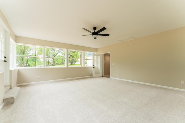 spare room with a ceiling fan, baseboards, and light carpet