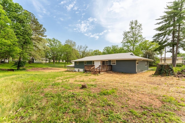 back of house with a wooden deck and a yard