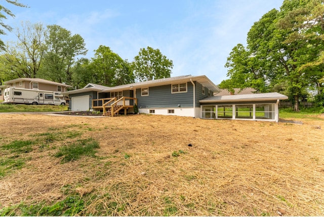 back of house featuring a sunroom and an attached garage