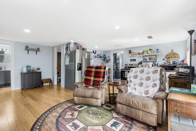 living room with recessed lighting, visible vents, and light wood-type flooring