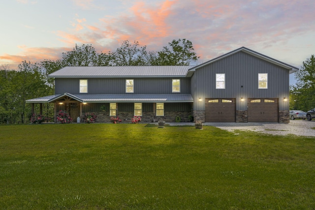 view of front of property featuring a lawn, driveway, and stone siding