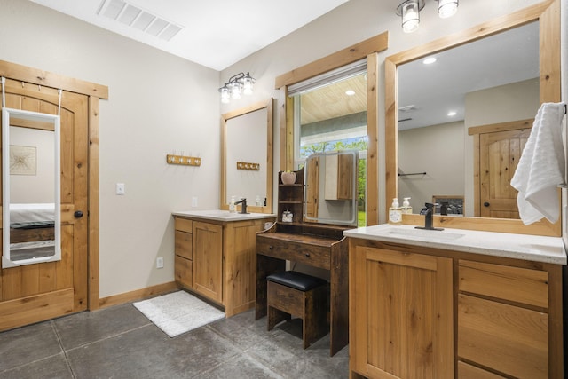 bathroom featuring a sink, two vanities, connected bathroom, and visible vents