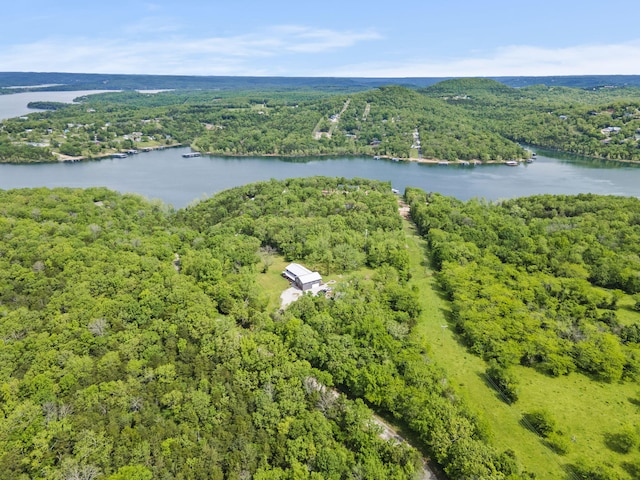 birds eye view of property featuring a water view and a wooded view