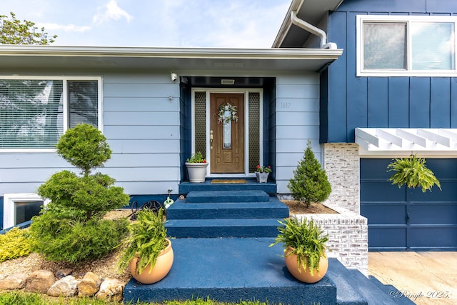 view of exterior entry featuring a garage and board and batten siding
