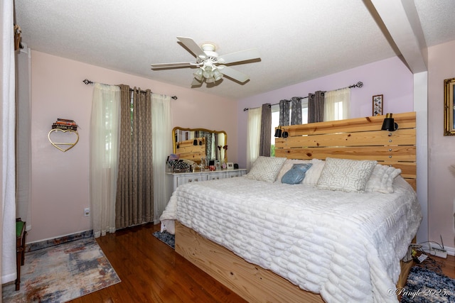 bedroom featuring a textured ceiling, baseboards, a ceiling fan, and wood finished floors