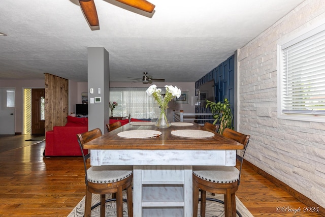dining area with wood finished floors and ceiling fan