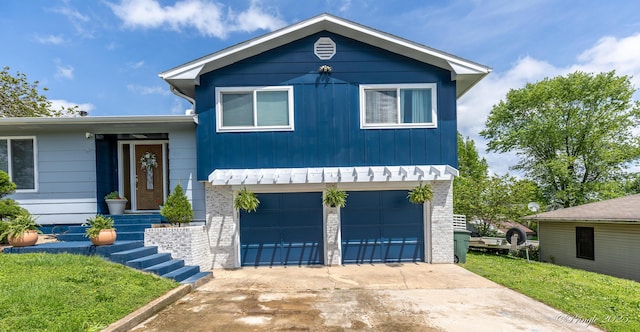 split level home featuring concrete driveway, board and batten siding, and an attached garage