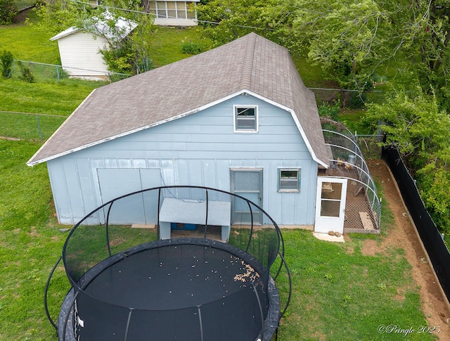 view of outbuilding featuring a trampoline and fence