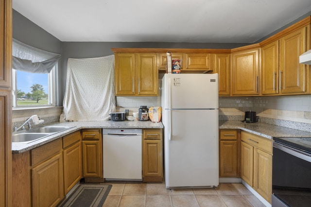 kitchen featuring white appliances, backsplash, brown cabinets, and a sink