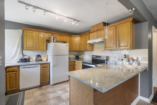 kitchen with light stone counters, white appliances, a peninsula, backsplash, and under cabinet range hood