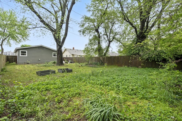 view of yard with a garden and a fenced backyard