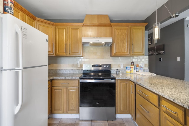 kitchen featuring light stone countertops, stainless steel range with electric stovetop, freestanding refrigerator, decorative backsplash, and under cabinet range hood