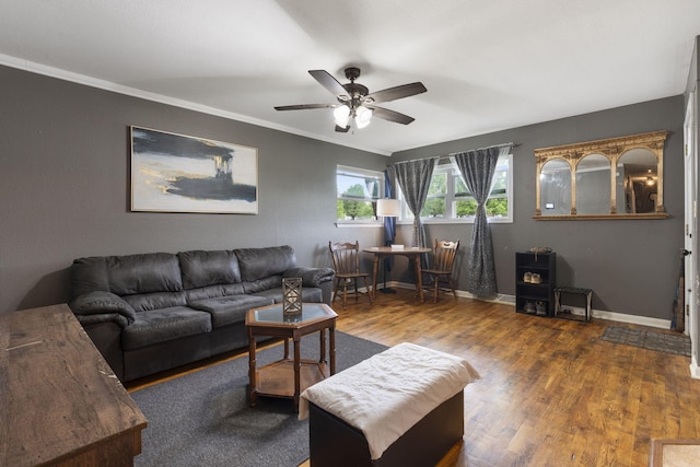living room with baseboards, ornamental molding, ceiling fan, and wood finished floors