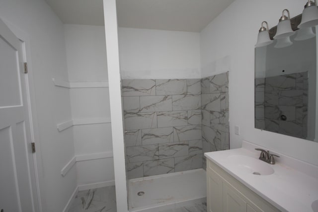 bathroom with vanity, tiled shower, and marble finish floor