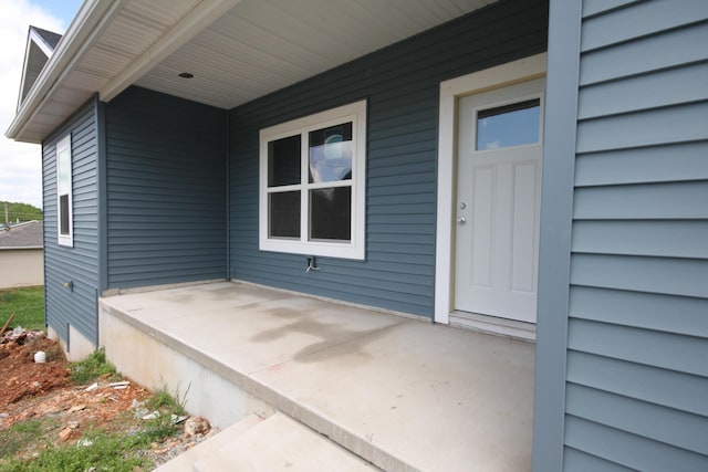 view of exterior entry with a patio area