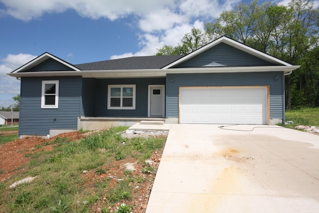 ranch-style home featuring a garage, concrete driveway, and a porch