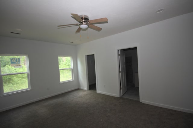 unfurnished bedroom featuring baseboards, carpet floors, ensuite bath, and ceiling fan