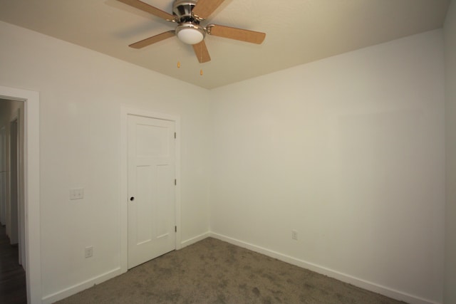 spare room featuring ceiling fan, baseboards, and dark colored carpet