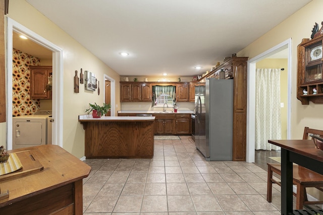 1730 N Pine St, Marshfield, MO 65706 - kitchen with freestanding refrigerator, washer / dryer, a peninsula, a sink, and light tile patterned floors