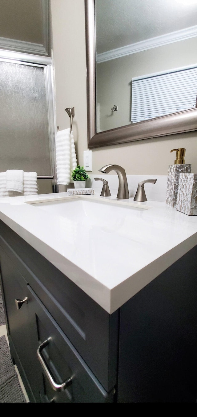 bathroom featuring crown molding and vanity