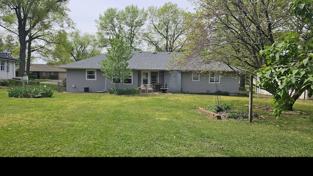 rear view of house featuring a lawn, a patio, fence, and roof with shingles