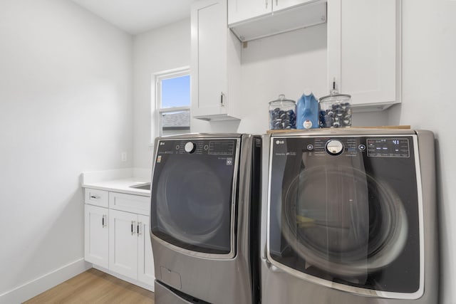 635 W Bridgewood Ct, Springfield, MO 65803 - laundry area with washer and clothes dryer, cabinet space, light wood-style flooring, and baseboards