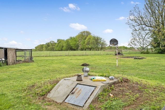 view of storm shelter with a lawn and a rural view