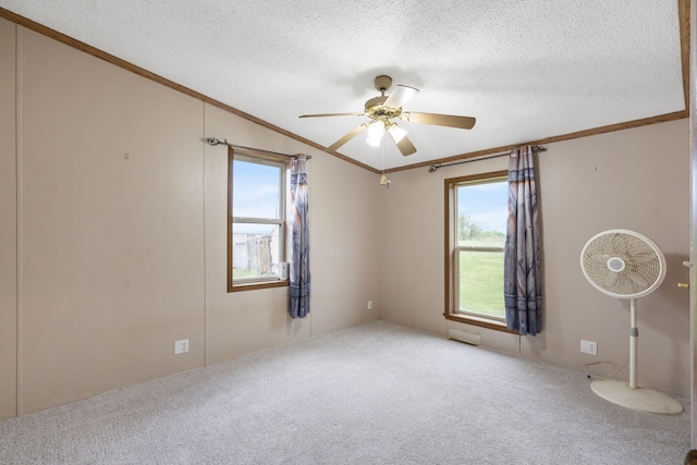 carpeted empty room featuring crown molding, a ceiling fan, a textured ceiling, and a wealth of natural light