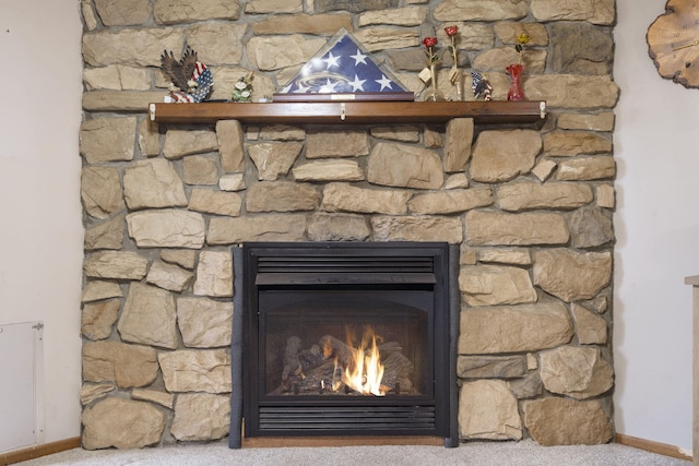 details featuring carpet flooring, baseboards, and a glass covered fireplace