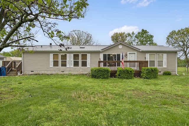 rear view of house featuring a lawn, crawl space, a wooden deck, and metal roof