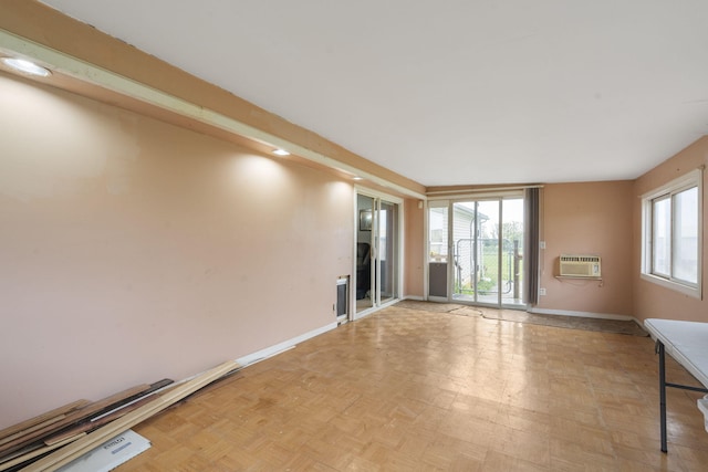 unfurnished room with baseboards and a wall mounted air conditioner