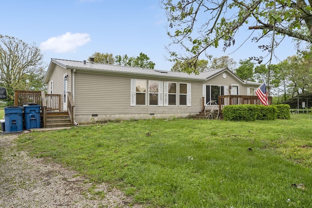 rear view of property featuring a lawn, crawl space, metal roof, and a deck