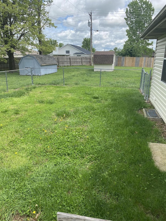view of yard featuring an outdoor structure, a shed, and a fenced backyard