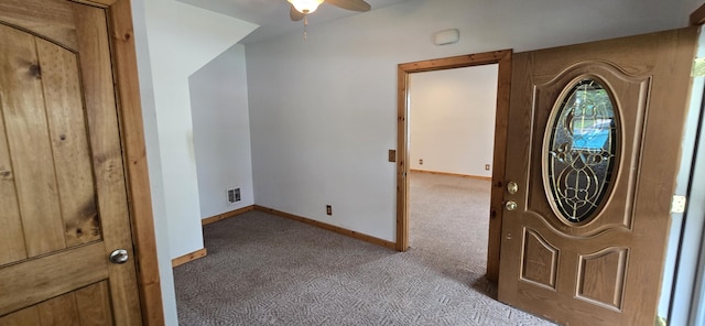 foyer featuring a ceiling fan, baseboards, visible vents, and carpet