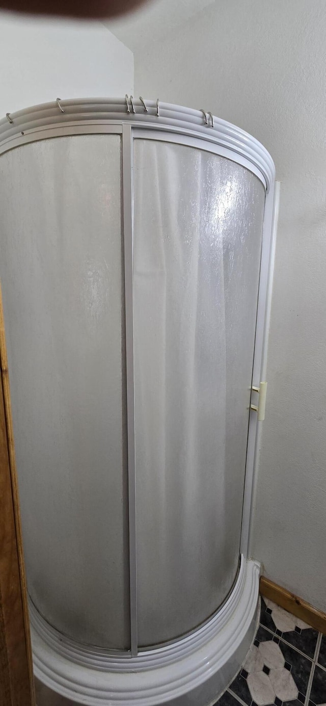 bathroom with tile patterned flooring and a stall shower