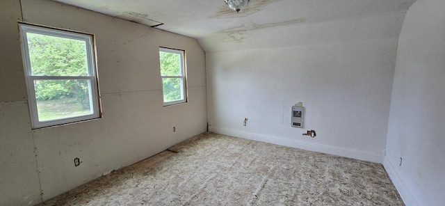 carpeted spare room featuring vaulted ceiling