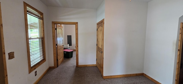 corridor with baseboards and carpet floors