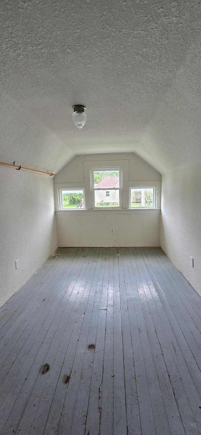 bonus room with a wealth of natural light, hardwood / wood-style flooring, a textured ceiling, and lofted ceiling