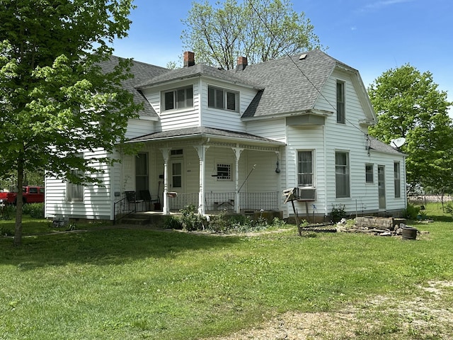 exterior space with a porch, a chimney, roof with shingles, cooling unit, and a yard