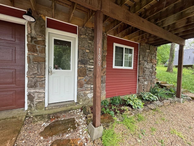 doorway to property featuring stone siding