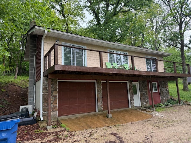 view of front facade featuring dirt driveway, a chimney, stone siding, and a garage