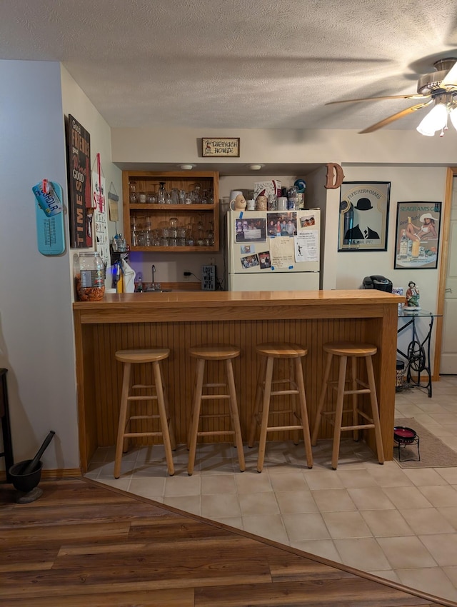 249 Mount Vernon Rd, Forsyth, MO 65653 - bar with freestanding refrigerator, indoor bar, and a textured ceiling