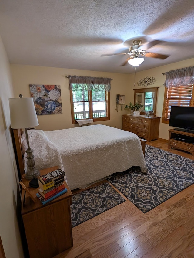 249 Mount Vernon Rd, Forsyth, MO 65653 - bedroom with a textured ceiling, multiple windows, and wood finished floors