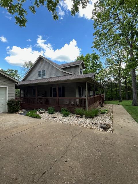 249 Mount Vernon Rd, Forsyth, MO 65653 - country-style home featuring a porch, a garage, and concrete driveway
