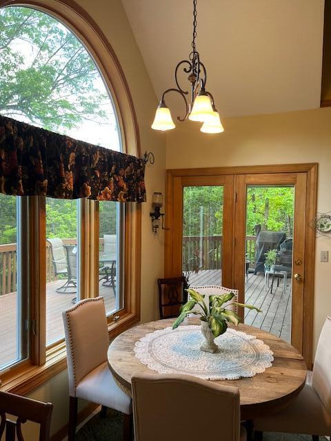 249 Mount Vernon Rd, Forsyth, MO 65653 - dining room with a notable chandelier, a wealth of natural light, and high vaulted ceiling