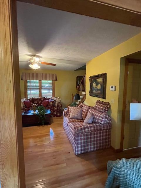 249 Mount Vernon Rd, Forsyth, MO 65653 - living room with stairway, a ceiling fan, and wood finished floors