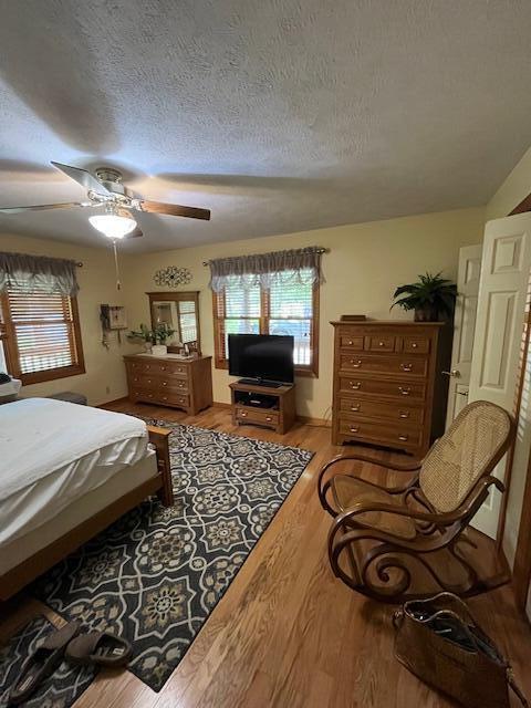 249 Mount Vernon Rd, Forsyth, MO 65653 - bedroom featuring a ceiling fan, a textured ceiling, and wood finished floors