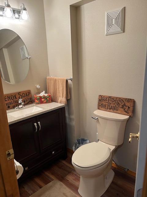 249 Mount Vernon Rd, Forsyth, MO 65653 - half bathroom featuring toilet, wood finished floors, and vanity