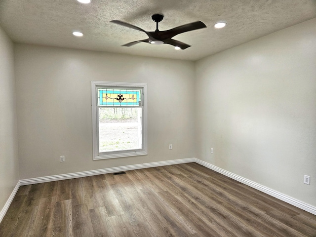 empty room with baseboards, a textured ceiling, dark wood-style flooring, and recessed lighting