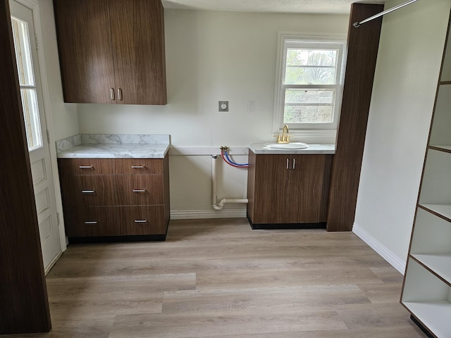 kitchen featuring light countertops, baseboards, and light wood-type flooring